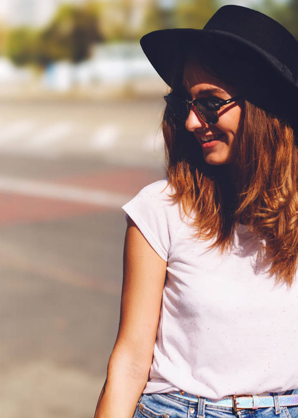 Sorrindo menina hipster em chapéu wlaking pela rua
 - Foto, Imagem