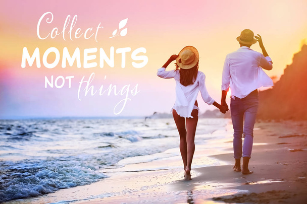 Young couple walking on seashore. Text COLLECT MOMENTS NOT THINGS on background - Foto, Imagem