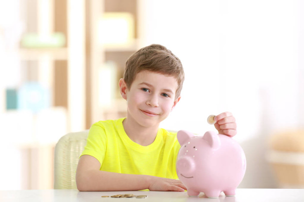 boy saving coins in piggy bank - Foto, Bild