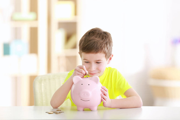 boy saving coins in piggy bank - Фото, зображення