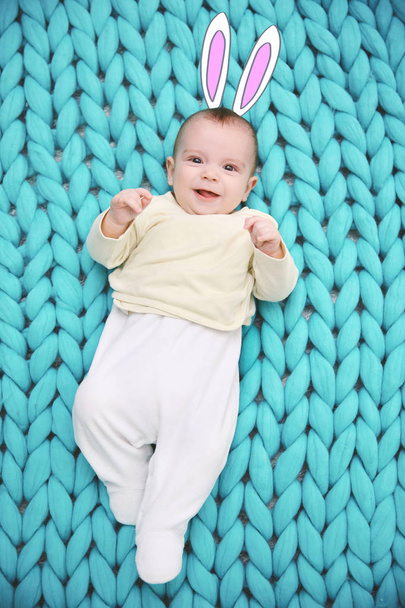 Cute baby with drawn bunny ears lying on plaid - Foto, afbeelding