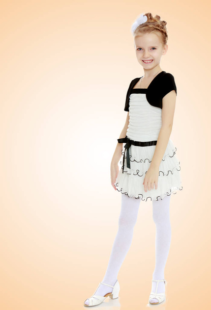 Beautiful little girl in a white short dress with a black belt. - Fotoğraf, Görsel