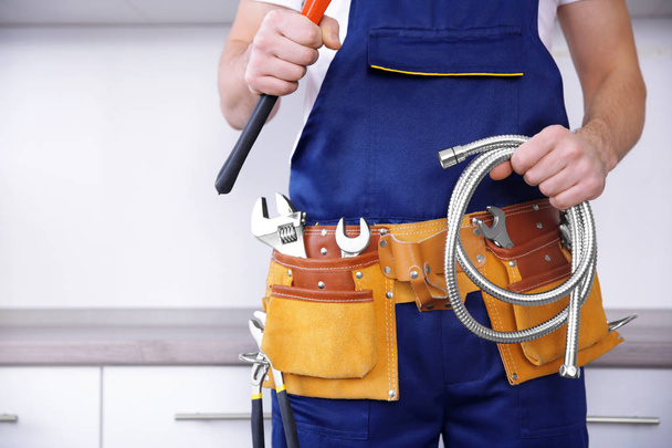 Plumber holding pipe wrench - Foto, afbeelding
