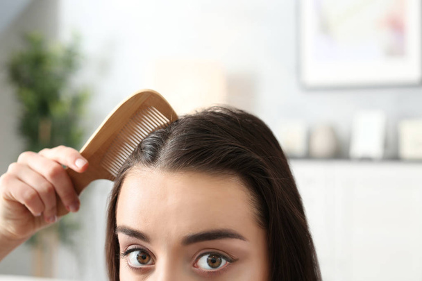 Young woman combing hair - Фото, зображення