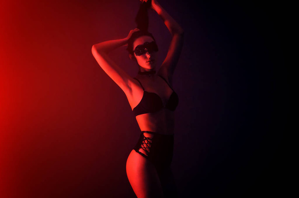 Model in seductive black lingerie with light neon colored spotlights - Photo, Image