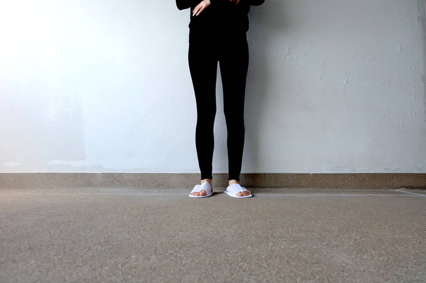 Closeup Photo of From Woman Wearing White Slippers and Black Pants  - Foto, Imagen