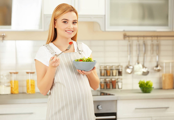  pregnant woman holding bowl with salad - 写真・画像