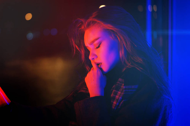 Sexy young woman posing over night city dramatic neon background - Zdjęcie, obraz