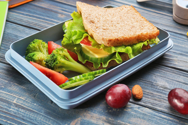 Lunch box with delicious food on wooden background - Foto, imagen