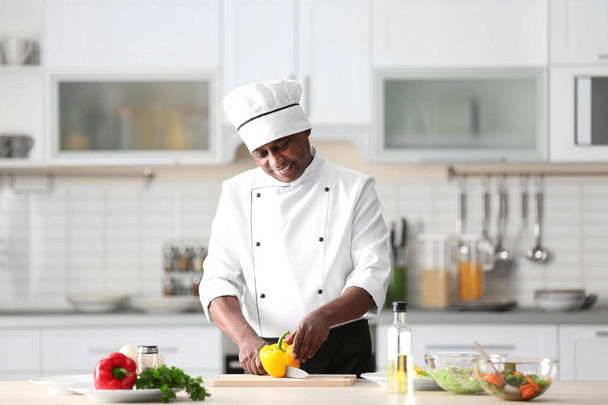 Mature Indian chef cooking in kitchen - Foto, Imagen