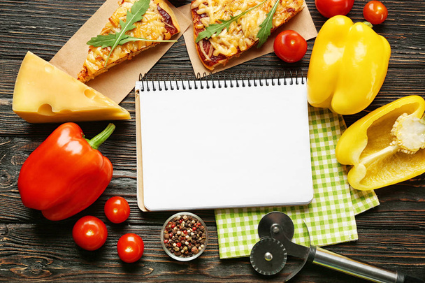 Still life with ingredients for pizza and recipe notebook on wooden table, top view - Фото, зображення