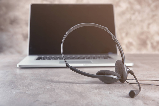 Headphones and laptop on grey table - Foto, Bild