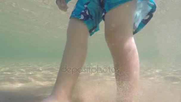 Underwater of toddler bare feet walking in ocean - Materiał filmowy, wideo