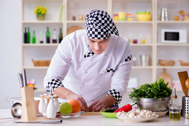 Genç aşçı mutfakta çalışıyor. - Fotoğraf, Görsel