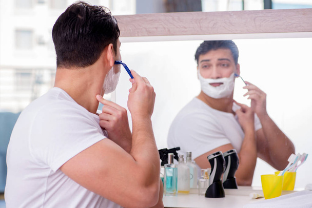 Genç yakışıklı adam sabahları tıraş oluyor. - Fotoğraf, Görsel