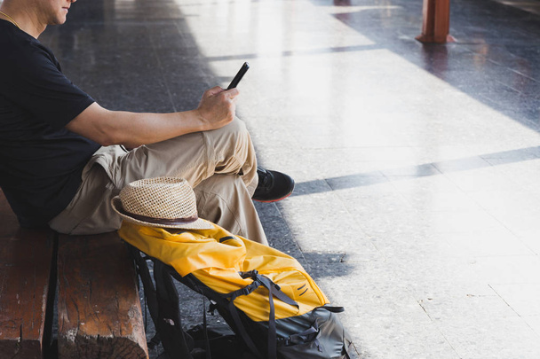 Mladý muž čekající na nástupišti stanice s batohem na vlaku - Fotografie, Obrázek