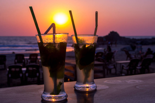 Mojito cocktail στην παραλία, ηλιοβασίλεμα και τη θάλασσα στο παρασκήνιο - Φωτογραφία, εικόνα