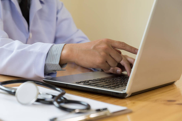 Dottore che mostra le cartelle cliniche sul suo computer, sta indicando un
 - Foto, immagini