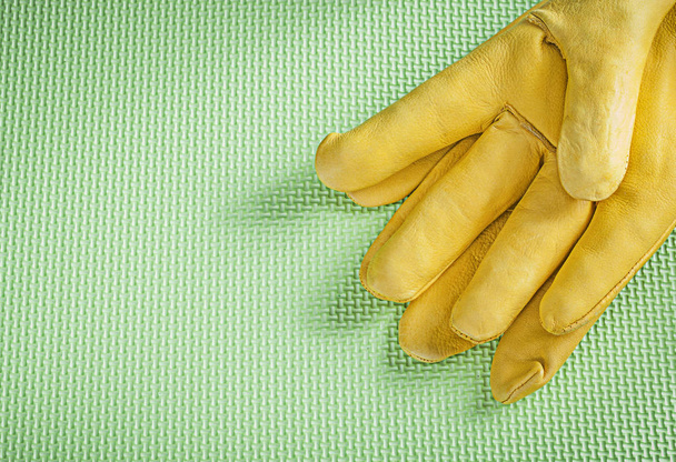 Leather protective gloves on green background construction conce - 写真・画像