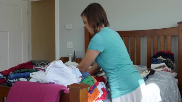 mother sorts through the kids clothes - Πλάνα, βίντεο
