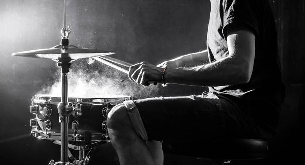 man plays musical percussion instrument with sticks, a musical concept, beautiful lighting on the stage - Photo, Image