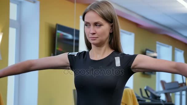 Mladá žena cvičit s činkami v posilovně - Záběry, video