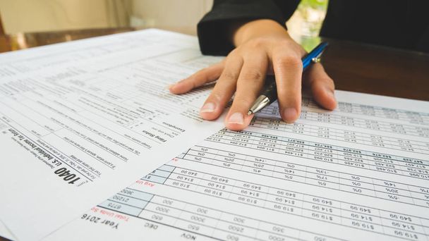 Zakelijke vrouw hand houden op het papier van belasting formulieren in business conc - Foto, afbeelding