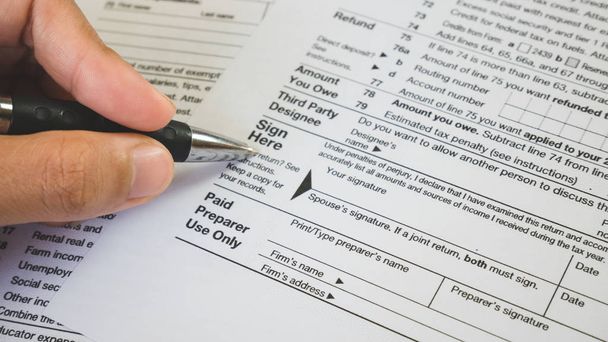 Caneta de mão no ponto de sinalização no papel de formulários fiscais na empresa c
 - Foto, Imagem