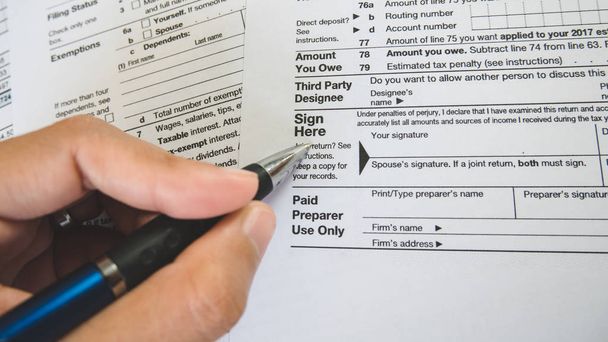Hand hold pen on sign point on the tax forms paper in business c - Photo, Image