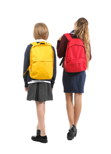 Two cute girls in school uniform on white background - Zdjęcie, obraz