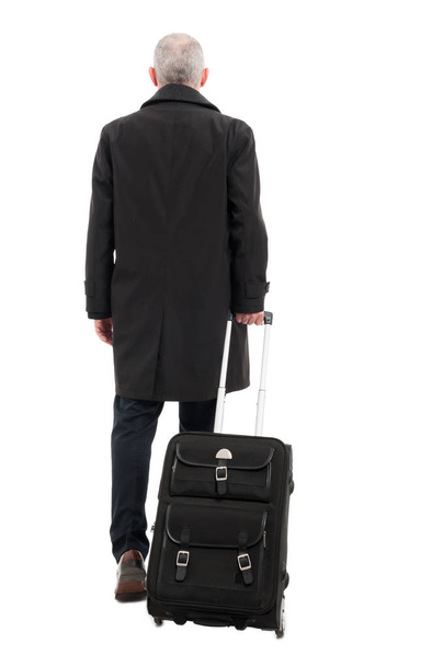 Back view of business man with carry on luggage - Фото, изображение