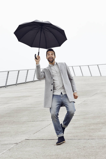 Excited guy with umbrella  - 写真・画像