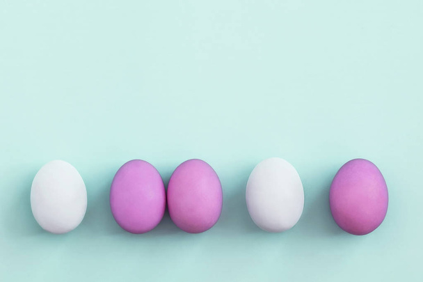 Row of colorful Easter eggs on blue background  - Photo, image