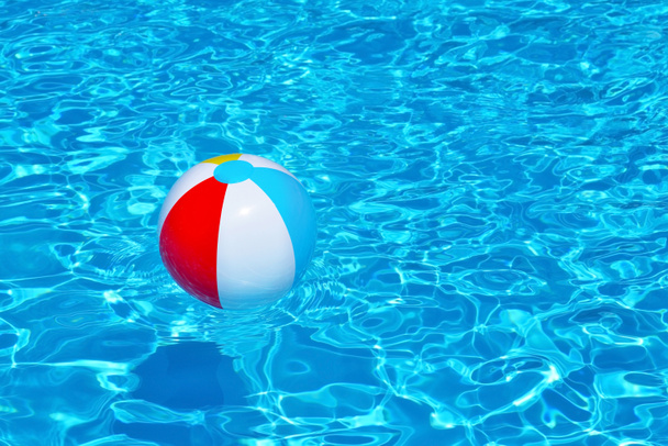 Барвистий надувний м'яч, що плаває у басейні
 - Фото, зображення