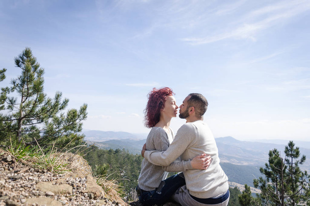 boy and girl sit cuddled on the mountain - 写真・画像
