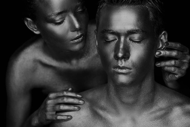 A girl and a guy covered in gold paint. With my eyes closed. The girl leaned, Black and white - Foto, Imagen