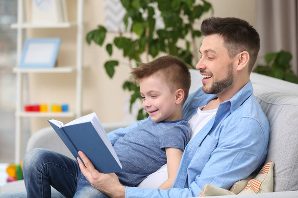 Dad and son reading book - Фото, изображение