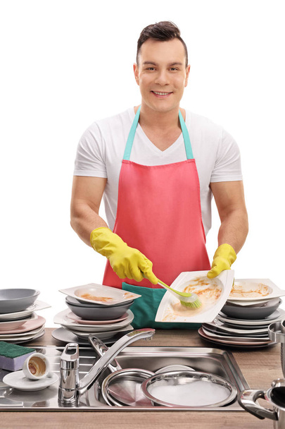 Cheerful young man doing the dishes - Фото, зображення