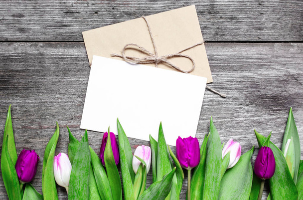 blank white greeting card and envelope with purple and pink tulips - Foto, Imagen