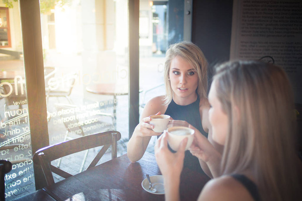 young girlfriends enjoying a cup of coffee  - Фото, изображение