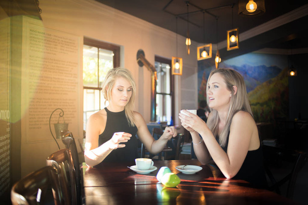 young girlfriends enjoying a cup of coffee  - Zdjęcie, obraz