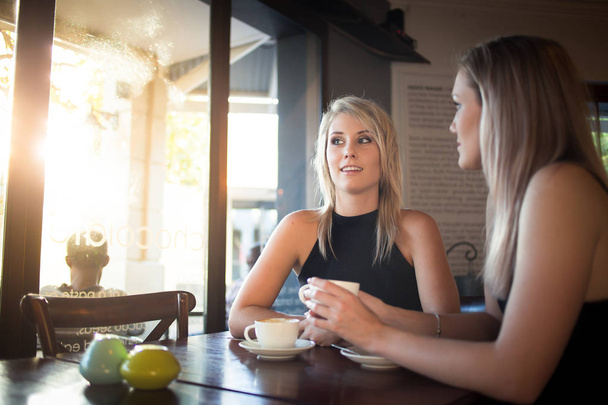 young girlfriends enjoying a cup of coffee  - Photo, Image