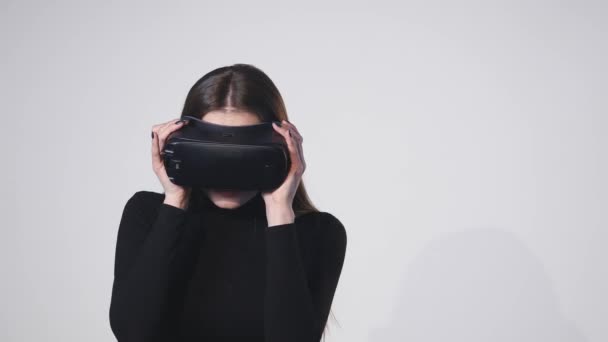 Woman uses a head mounted display. A woman in a virtual reality mask looks around - Imágenes, Vídeo