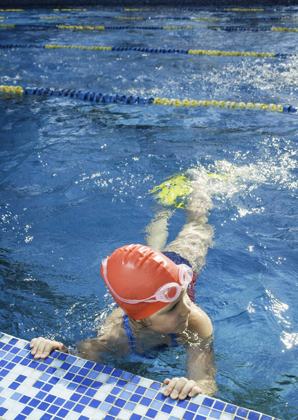 Молода дівчина вчиться плавати в басейні
 - Фото, зображення
