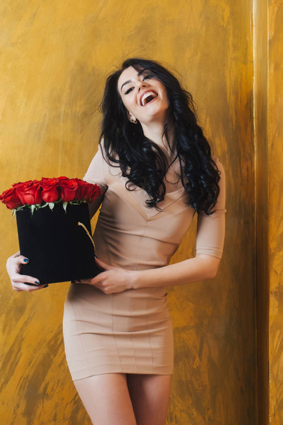 Pretty happy girl laughing with red roses in box - 写真・画像