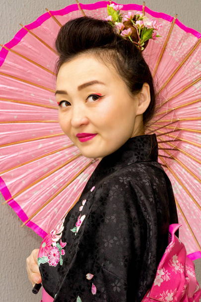 prachtige geisha in traditionele Japanse kimono met parasol - Foto, afbeelding
