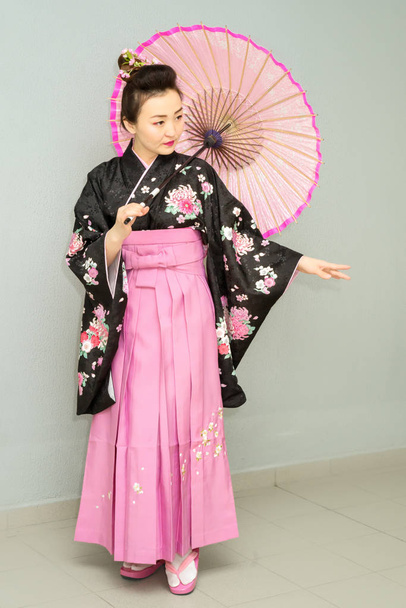 όμορφη γκέισα σε παραδοσιακό ιαπωνικό κιμονό με ομπρέλα - Φωτογραφία, εικόνα
