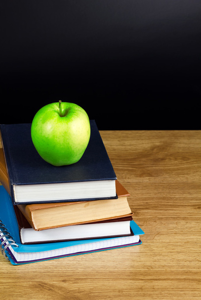 Books and apple in wood table - 写真・画像