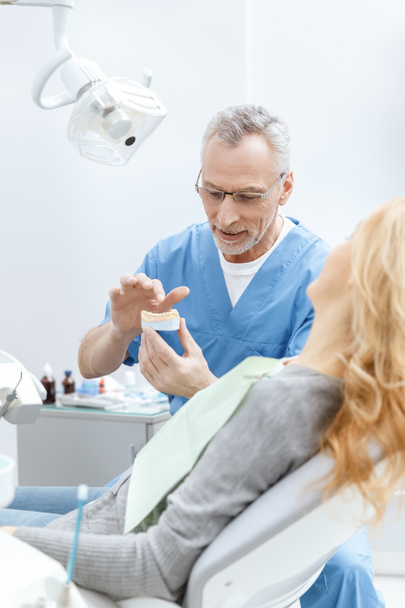 dentista mostrando mordazas modelo
 - Foto, imagen