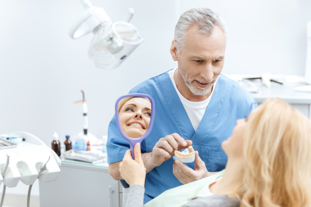 стоматолог, що показує модель щелеп
 - Фото, зображення